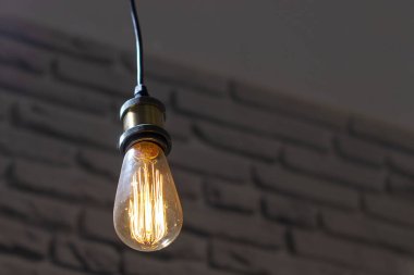 Koyu tuğla duvar ve açık tavan arka planda retro şeklinde Lamba. Alt görünüm