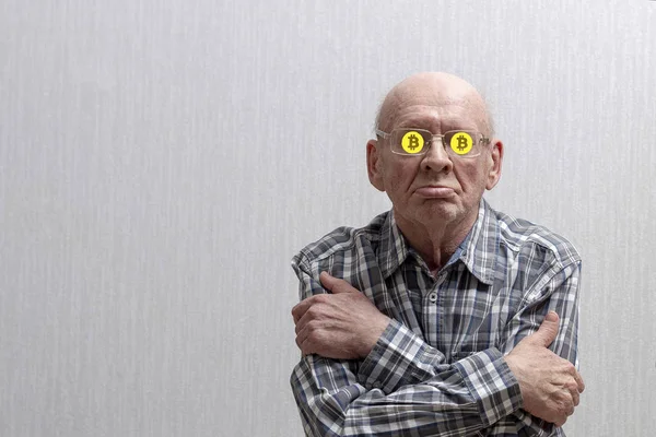 Gri arka planda gözlüklü yaşlı bir adam kollarını göğsüne geçirdi ve gözlüklerinin içinde bitcoin işaretine oturdu. Portre. Ön görünüm