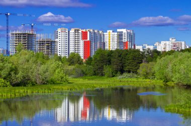 Şehirde yeni binalar ve orman ile nehir. Ön görünüm