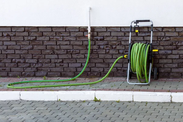 Uma Mangueira Verde Portátil Carretel Para Regar Gramado Flores Perto — Fotografia de Stock