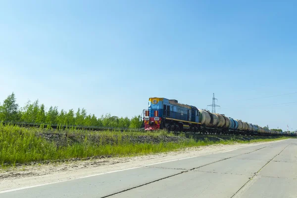 Eine Blaue Lokomotive Zieht Einen Kesselwagen Gegen Einen Blauen Himmel — Stockfoto