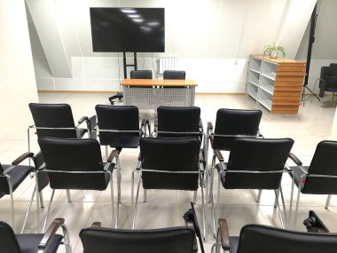 Eğitim amaçlı sandalye ve tv içeren bir oda. Geri görünüm.