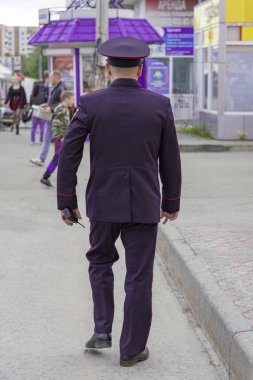 Şehirde üniformalı bir polis memuru caddede yürüyor. Surgut, Rusya - 12 Haziran 2019.
