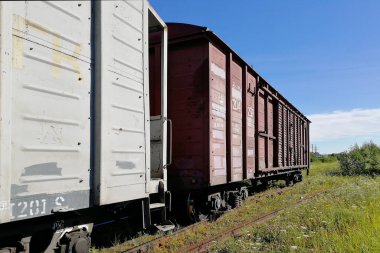 Raylı vagonlar. Birlikte çekildik. Açık gökyüzü ve güneşli bir gün. Yatay bir perspektif.