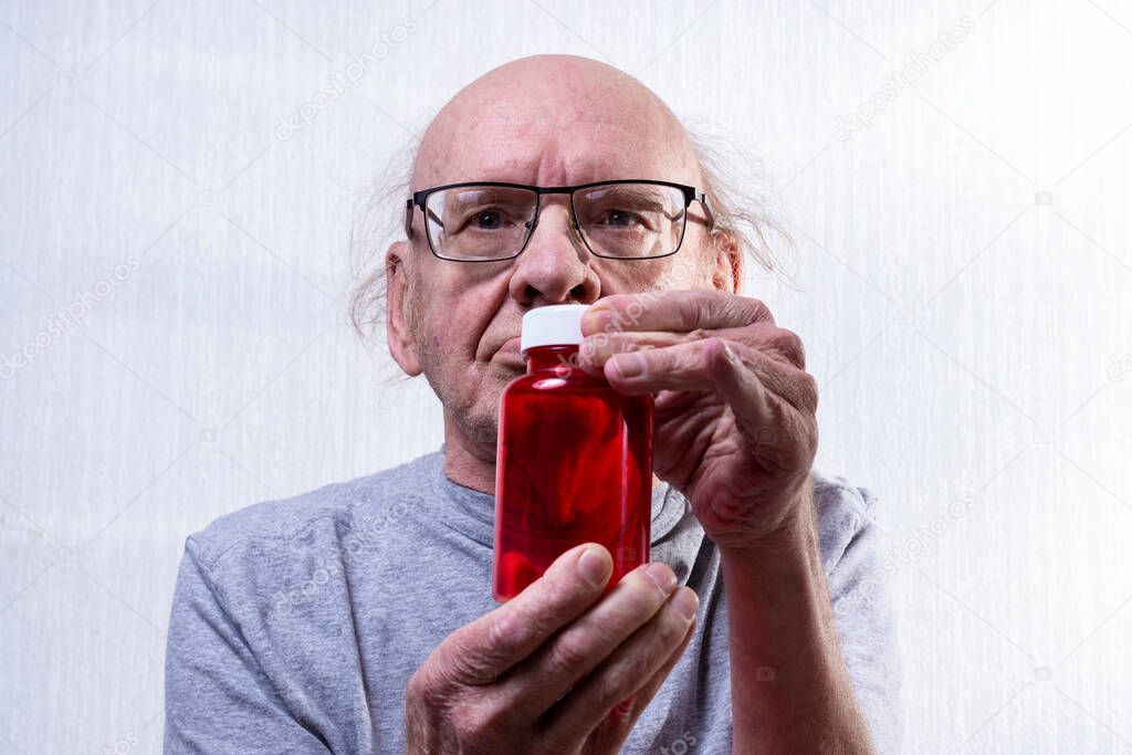 Old man with jar. View from the front. Portrait. A jar of red. Electoral focus.