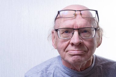 İki kadehli yaşlı bir adam. Burnunda bardaklar, alnında da diğerleri. Portre. Boşluğu kopyala.