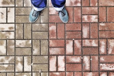 Pantolon giymiş erkek bacakları ve arka planda çok renkli beton fayansların spor ayakkabıları. Üst Manzara. Boşluğu kopyala.