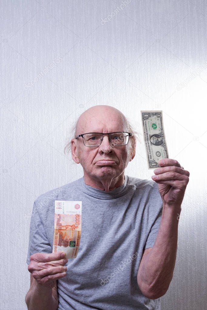 Old man with bills. In one hand five thousand rubles in the other one dollar.