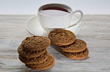 Ahşap arka planda bisküvi ve bir fincan çay