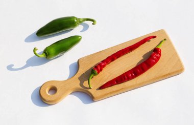 tahta ve açık arka plan üzerinde kırmızı ve yeşil biber