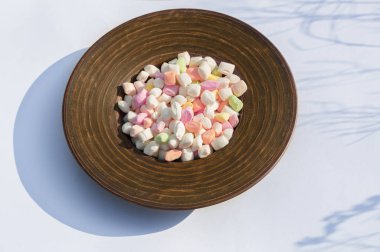 açık bir arka plan üzerinde derin bir çanak renkli şeker