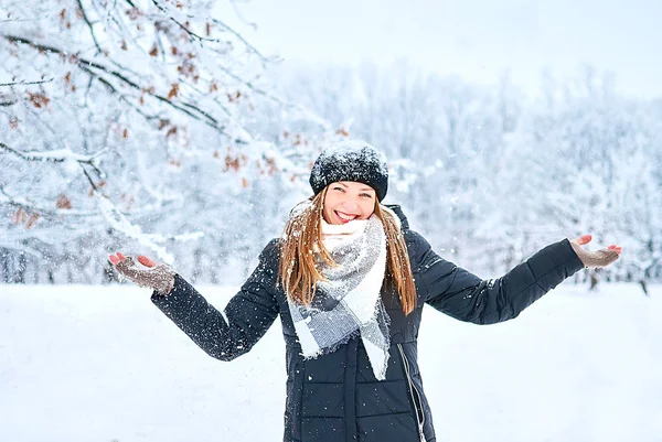 Schönes Mädchen spielt mit Schnee im Park — Stockfoto