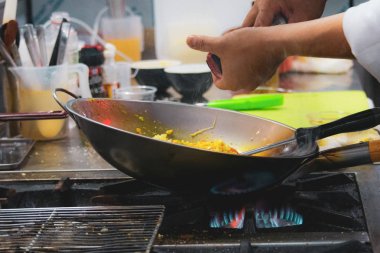 Şef bir tavada bir mutfak soba, soba pan ile Restoran mutfakta Şef üzerinde alev ile yemek yaparken gıda flambe