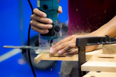 Bir marangoz atölyesinde ahşap tahta üzerinde elektrikli planya ile çalışma