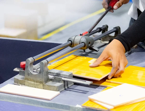 Cutting the floor tiles using a tile cutter machine, cutting ceramic tiles with handy machine