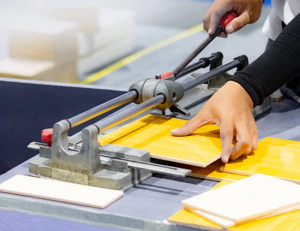 Cutting the floor tiles using a tile cutter machine, cutting ceramic tiles with handy machine