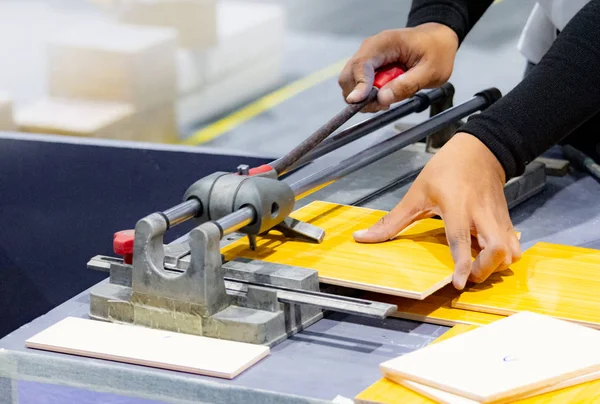 Cutting the floor tiles using a tile cutter machine, cutting ceramic tiles with handy machine