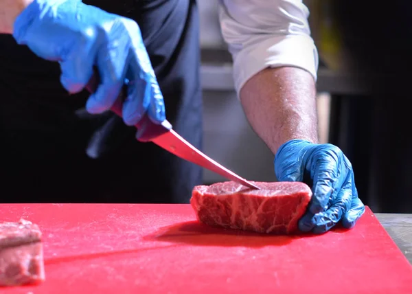 Butcher cutting pork meat, Chef cutting fresh raw meat, Chef cooking food in the kitchen