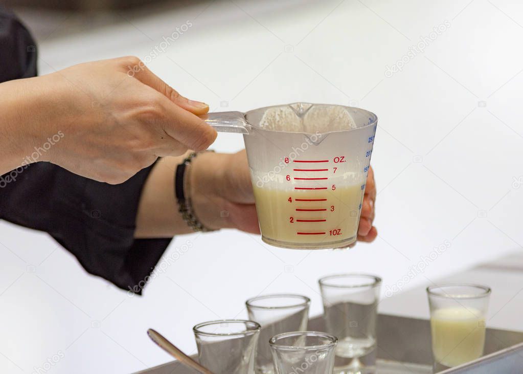 Measuring out milk in a measuring jug for cooking or test