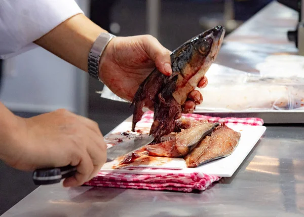 Chef cutting fish, Chef slices fish fresh on Board in the kitchen