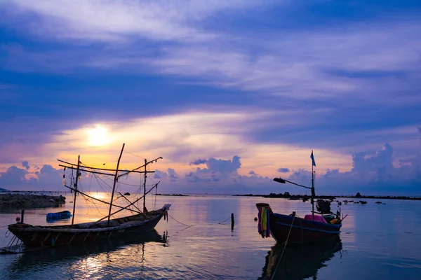 Barco de pesca no mar, pôr do sol e silhuetas de barcos de madeira — Fotografia de Stock