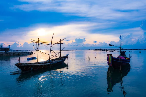 Barco de pesca no mar, pôr do sol e silhuetas de barcos de madeira — Fotografia de Stock