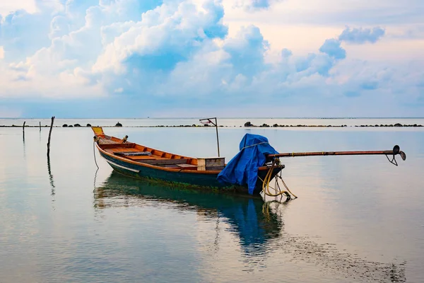 Barco de pesca en el mar, puesta del sol y siluetas de barcos de madera — Foto de Stock