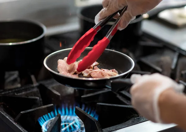 Kuchařka vaření v kuchyni, čerstvá smažená slanina v pánvi — Stock fotografie