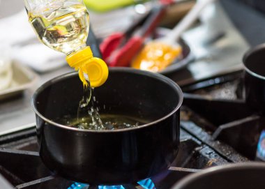 Şef Aşçı yemek yemek mutfakta tavada yağ boşaltma