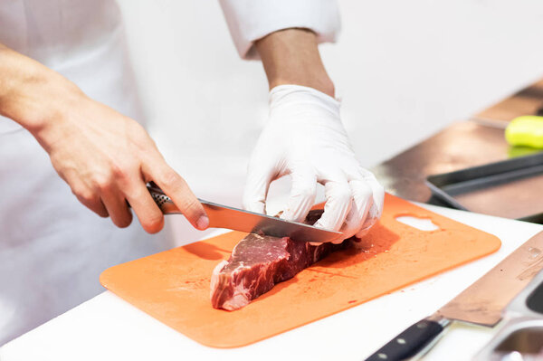 Chef cutting fresh raw meat with knife in the kitchen, Chef cutt