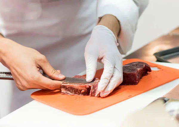 Chef cutting fresh raw meat with knife in the kitchen, Chef cutt