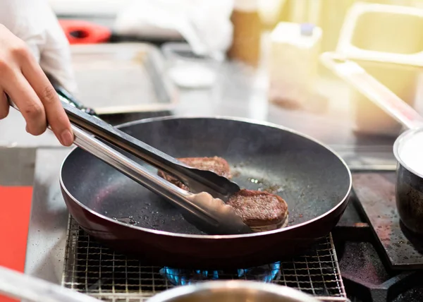 Bir tavada et kızartın. Şef hazırlama ve et re spicing — Stok fotoğraf
