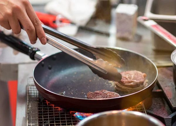 Freír la carne en una sartén. Chef preparando y condimentando carne re — Foto de Stock