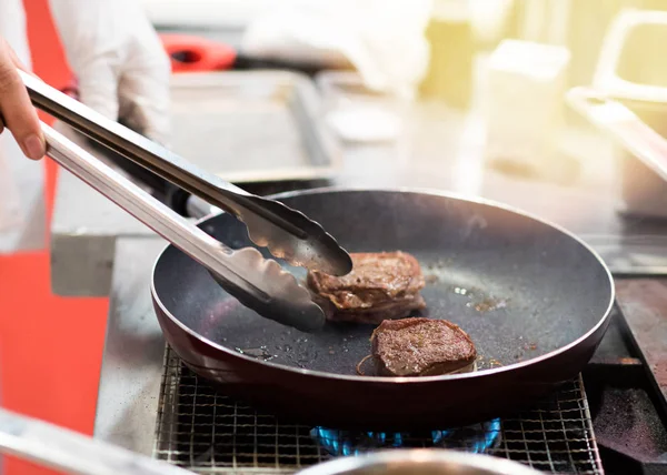 Freír la carne en una sartén. Chef preparando y condimentando carne re — Foto de Stock