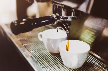 Espresso makinesi kahve demliyor. Kahve bardak içine dökülen i