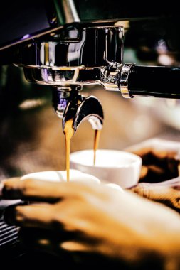 Espresso makinesi kahve demliyor. Kahve bardak içine dökülen i