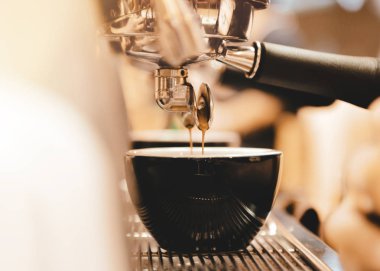 Espresso makinesi kahve demliyor. Kahve bardak içine dökülen i