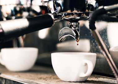 Espresso makinesi kahve demliyor. Kahve bardak içine dökülen i