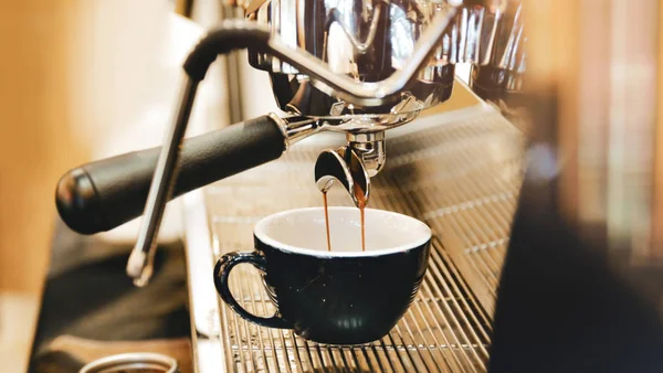Espresso makinesi kahve demliyor. Kahve bardak içine dökülen i — Stok fotoğraf