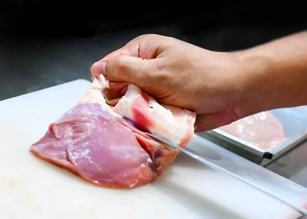 chef cutting Chicken fillet breast on board, chef cutting raw chicken meat