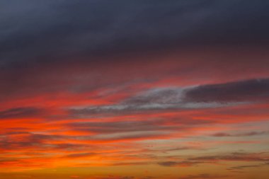 Gökyüzü. Günbatımı güzel, renkli bulutlar ile. Parlak mavi, turuncu ve sarı renkler. Görünümü arıyorum. Yakın çekim.