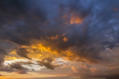Gökyüzü. Günbatımı güzel, renkli bulutlar ile. Parlak mavi, turuncu ve sarı renkler. Görünümü arıyorum. Yakın çekim.