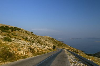 Mavi gökyüzü ve yakındaki sahil manzaralı dağlardaki güzel yol manzarası. Güzel Deniz Manzarası Hırvatistan. Hırvatistan tatili.