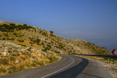 Mavi gökyüzü ve yakındaki sahil manzaralı dağlardaki güzel yol manzarası. Güzel Deniz Manzarası Hırvatistan. Hırvatistan tatili.