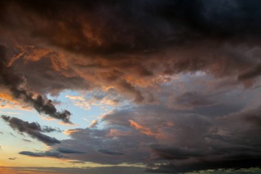 Gökyüzü. Günbatımı güzel, renkli bulutlar ile. Parlak mavi, turuncu ve sarı renkler. Görünümü arıyorum. Yakın çekim.