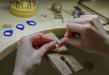 Profession jeweler. Hands working jeweler at jeweller's workshop , handwork. Craft jewelery making. clipart