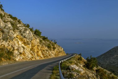 Mavi gökyüzü ve yakındaki sahil manzaralı dağlardaki güzel yol manzarası. Güzel Deniz Manzarası Hırvatistan. Hırvatistan tatili.