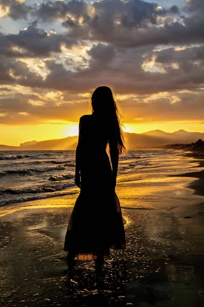 Issız deniz plaj arka planı Genç, güzel bir kadın silüeti.