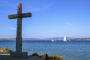 Stone cross installed near the sea. Christian symbolism. In the background is the sea.  Landscape and nature.