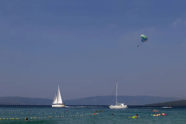 Croatian beach at a sunny day.  Sport and ocean activity on beach holiday. Adriatic sea .Summer vacation.  Concept of summer adventures, holidays, active summer holidays .